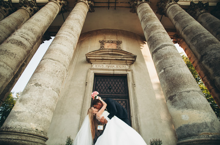 Beautiful romantic wedding couple of newlyweds kissing near old castle.の写真素材