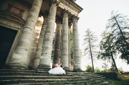 Beautiful romantic wedding couple of newlyweds hugging near old castle.の写真素材