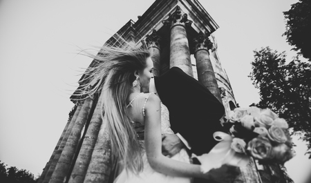 Beautiful romantic wedding couple of newlyweds hugging near old castle.の写真素材