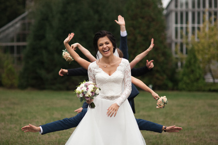 Beautiful brunette bride in elegant white dress holding bouquetの写真素材