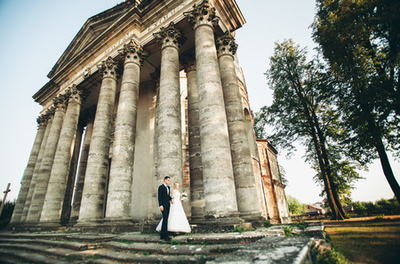 Beautiful romantic wedding couple of newlyweds hugging near old castle.の写真素材