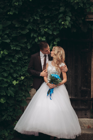 Happy wedding couple hugging and smiling each other on the background gorgeous plants in castle.の写真素材