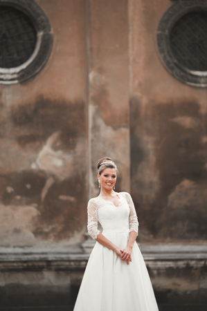 Wonderful bride with a luxurious white dress posing in the old town.の写真素材