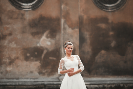 Wonderful bride with a luxurious white dress posing in the old town.の写真素材