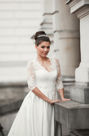Wonderful bride with a luxurious white dress posing in the old town.の写真素材