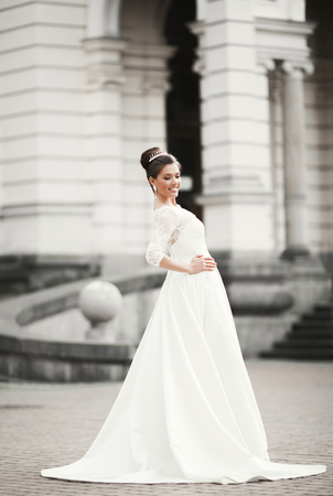 Wonderful bride with a luxurious white dress posing in the old town.の写真素材