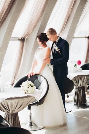 Happy wedding couple, bride and groom posing in hotel.の写真素材