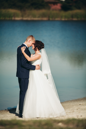 kiss of married young wedding couple near lake.の写真素材