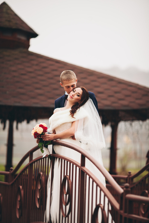 Happy wedding couple, bride and groom posing in park autumn.の写真素材