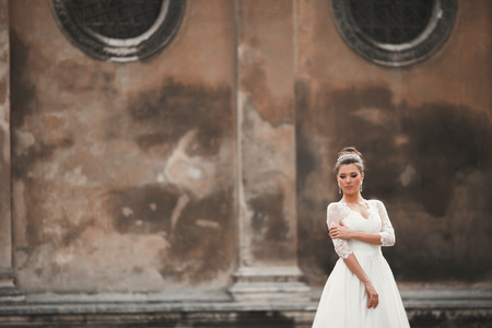 Wonderful bride with a luxurious white dress posing in the old town.の写真素材