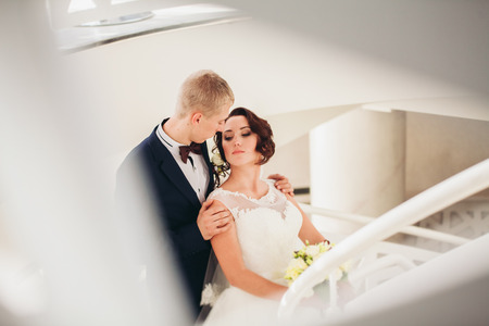 Happy wedding couple, bride and groom posing in hotel.の写真素材