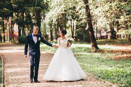 Happy wedding couple, bride and groom in park.の写真素材