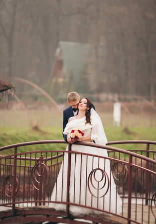 Happy wedding couple, bride and groom posing in park autumn.の写真素材