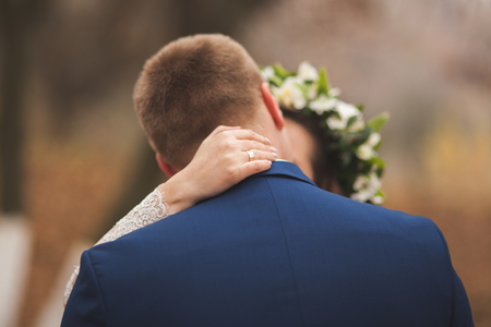 Happy wedding couple, bride and groom kissing in the autumn forest, park.の写真素材