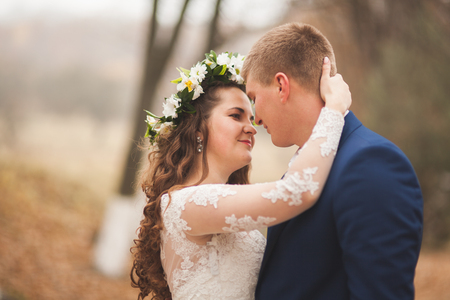 Happy wedding couple, bride and groom walking in the autumn forest, park.の写真素材
