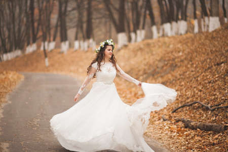 Beautiful bride posing in park and forest autumn.の写真素材