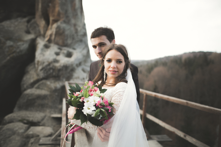 Happy wedding couple, bride and groom posing near rocks with beautiful views.の写真素材