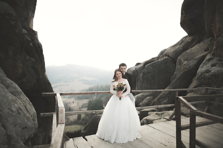 Happy wedding couple, bride and groom posing near rocks with beautiful views.の写真素材