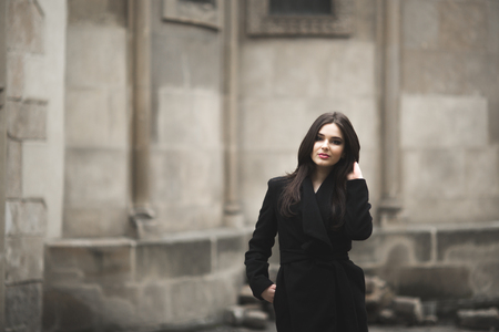Beautiful brunette young woman posing on the street in old city.の写真素材