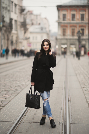 Beautiful brunette young woman posing on the street in old city.の写真素材