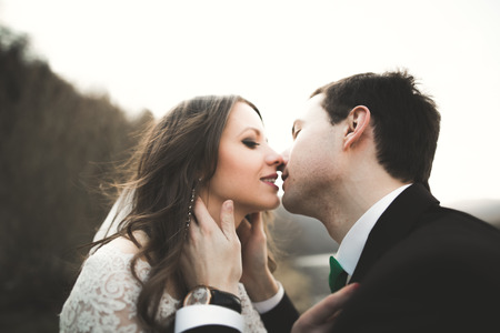 Happy newlyweds, bride and groom posing on river with beautiful views.の写真素材