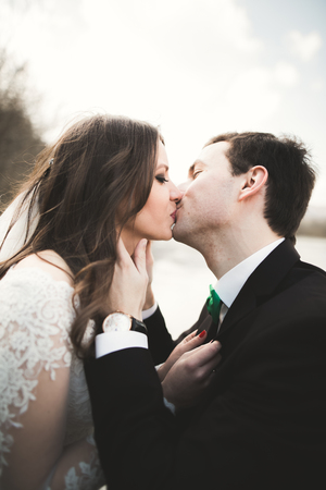 Happy newlyweds, bride and groom posing on river with beautiful views.の写真素材