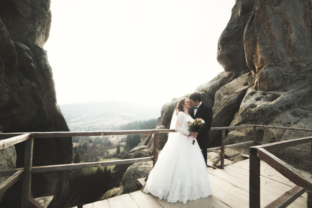 Wedding couple in love kissing and hugging near rocks on beautiful landscape.の写真素材