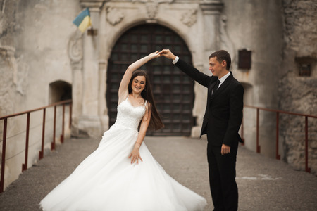 Happy wedding couple hugging and smiling each other on the background gorgeous plants in castle.の写真素材