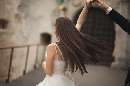 Happy wedding couple hugging and smiling each other on the background gorgeous plants in castle.の写真素材