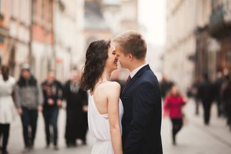 Gorgeous wedding couple, bride, groom hugging standing in the crowd.の写真素材