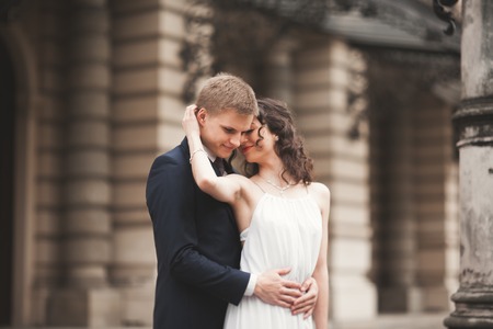 Beautiful wedding couple, bride, groom hugging against the background of theater.の写真素材