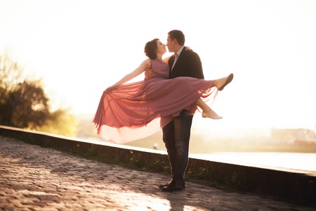 Wedding couple, groom and dress posing near river at sunset.の写真素材