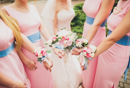 The bride and bridesmaids are showing beautiful flowers on their hands.の写真素材