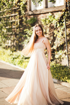 Attractive young woman with long dress enjoying her time outside in park sunset background.の写真素材