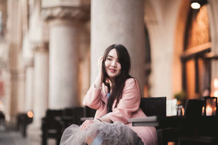 Beautiful Asian girl model in dress sitting at the old city background.の写真素材