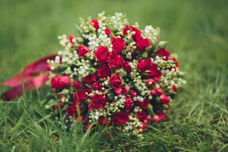 Bouquet of beautiful flowers and greenery is on the green grass.の写真素材
