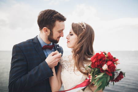 Married wedding couple standing on a wharf over the sea.の写真素材
