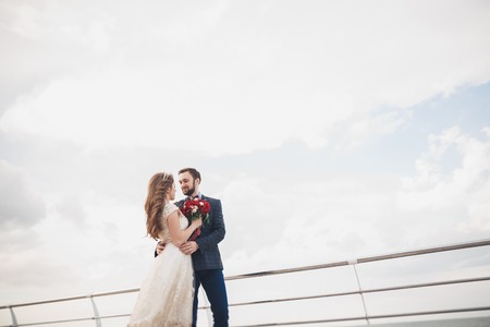 Just married couple on walking on the beach at sunset.の写真素材
