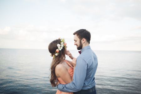 Beautiful loving couple, pride with long dress walking on pier.の写真素材