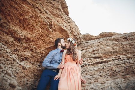 Romantic loving couple walking on the beach with rocks and stones.の写真素材