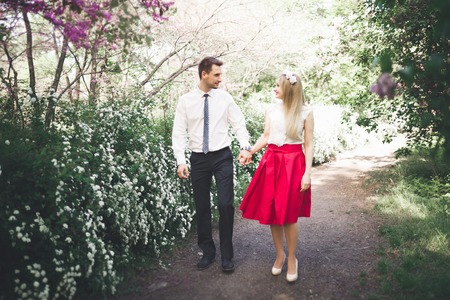 Stylish beautiful happy wedding couple kissing and embracing in Botanical Garden.の写真素材