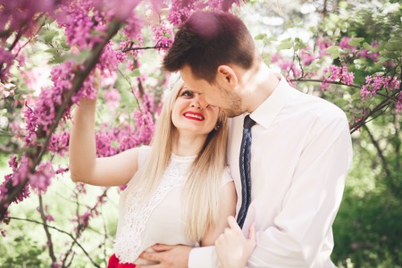 Stylish beautiful happy wedding couple kissing and embracing in Botanical Garden.の写真素材
