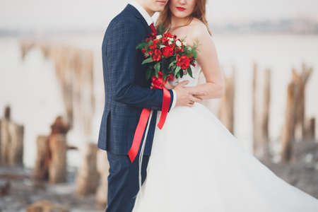 Beautiful wedding bouquet with various elegant flowers in hands of the bride.の写真素材