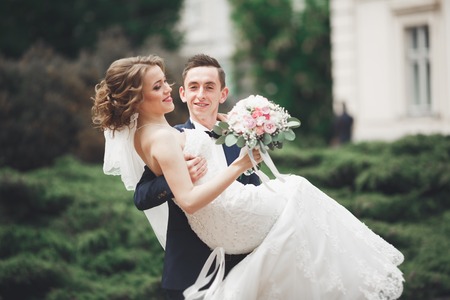 wedding couple is standing and kissing in the streets of old city.の写真素材