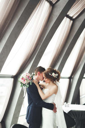 wedding couple is standing and kissing in hotel.の写真素材