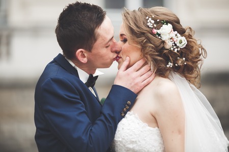 wedding couple is standing and kissing in the streets of old city.