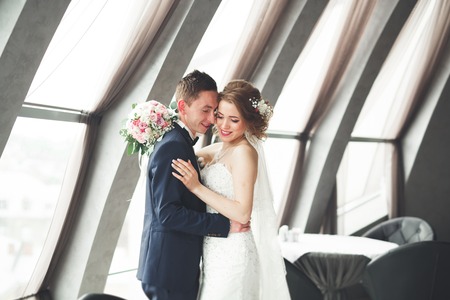 wedding couple is standing and kissing in hotel.の写真素材