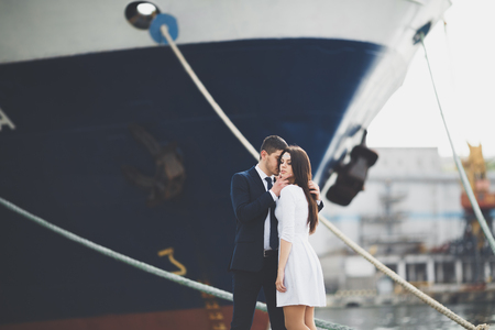 Happy bride and groom hugging near ship.の写真素材