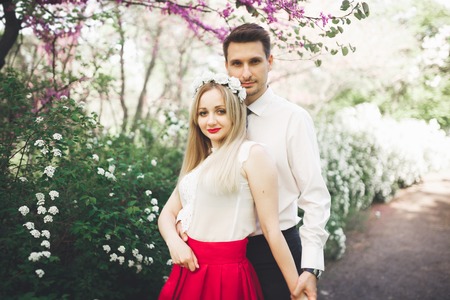 Stylish beautiful happy wedding couple kissing and embracing in Botanical Garden.の写真素材