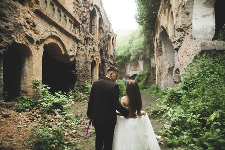 Just married poses in the light of sunset with an old fortress on the background.の写真素材